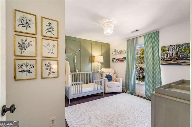 bedroom with an inviting chandelier and a crib