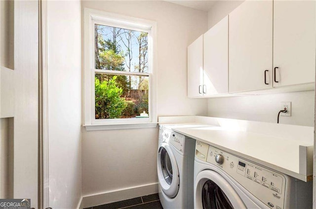 laundry room with cabinets, dark tile patterned floors, and independent washer and dryer