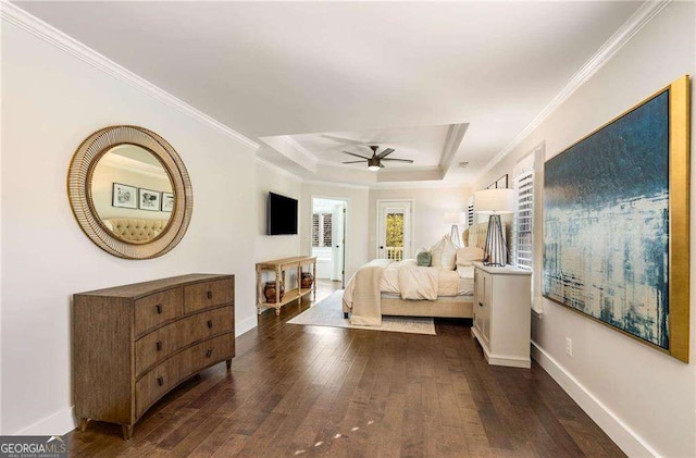 bedroom with ceiling fan, dark wood-type flooring, crown molding, and a tray ceiling