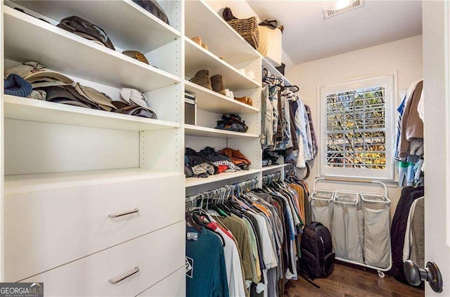 walk in closet with dark wood-type flooring