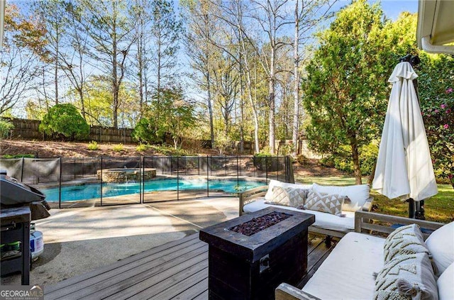 wooden deck featuring an outdoor living space with a fire pit and a fenced in pool