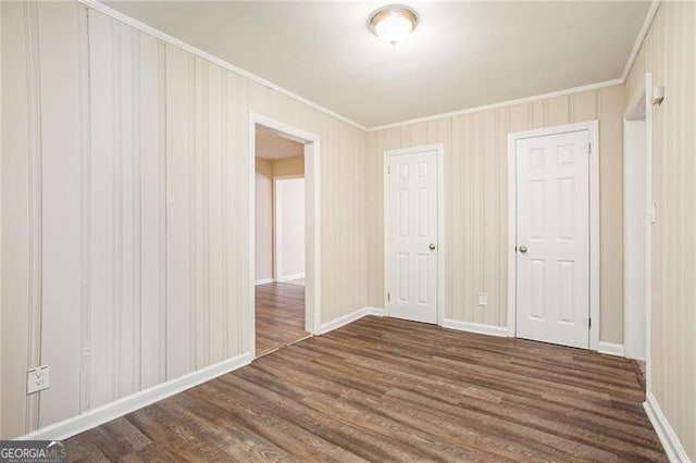 spare room with dark wood-type flooring and ornamental molding