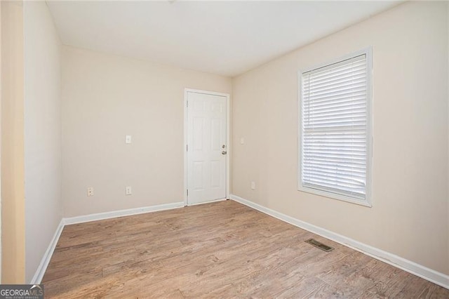 unfurnished room with light wood-type flooring