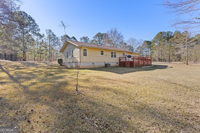 rear view of property with a lawn, cooling unit, and a deck