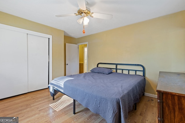 bedroom with a closet, light hardwood / wood-style flooring, and ceiling fan