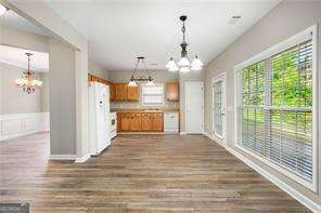 kitchen with a chandelier, pendant lighting, white refrigerator, and dark wood-type flooring