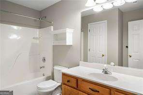 full bathroom with vanity, toilet, and washtub / shower combination