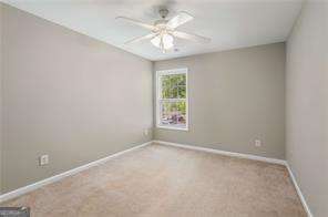 empty room with light colored carpet and ceiling fan