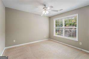 spare room featuring light colored carpet and ceiling fan