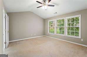 unfurnished bedroom with ceiling fan, light carpet, and vaulted ceiling