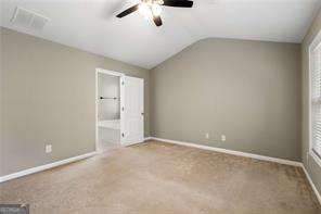 unfurnished bedroom featuring carpet flooring and lofted ceiling