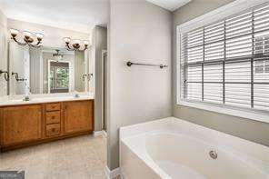 bathroom featuring tile patterned flooring, vanity, and separate shower and tub