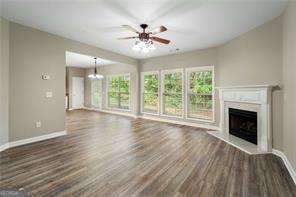 unfurnished living room with ceiling fan and dark hardwood / wood-style floors