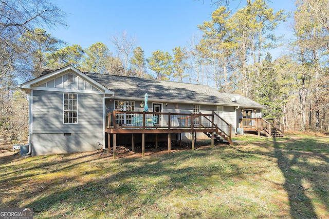 rear view of property featuring a lawn and a wooden deck