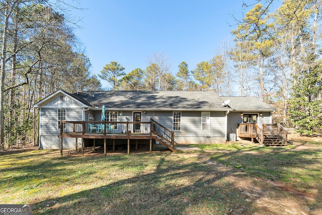 rear view of house with a lawn and a deck