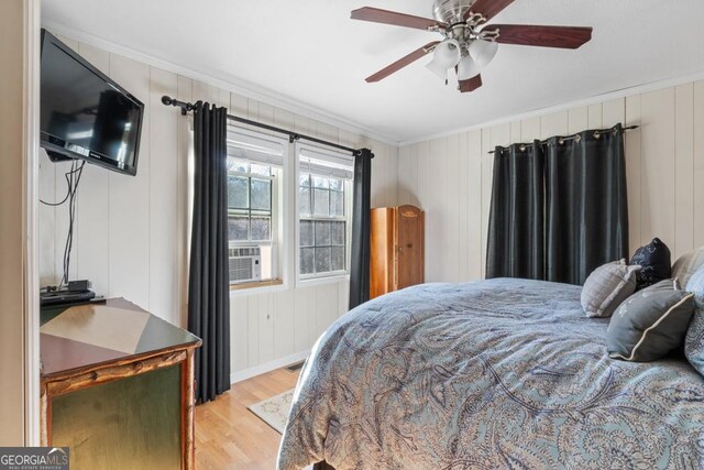 bedroom featuring ceiling fan, crown molding, cooling unit, and light hardwood / wood-style floors