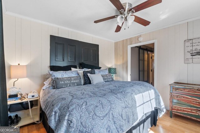 bedroom featuring ceiling fan, wood-type flooring, and crown molding