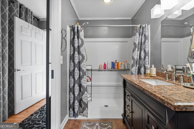 bathroom with vanity, a textured ceiling, crown molding, wood-type flooring, and curtained shower