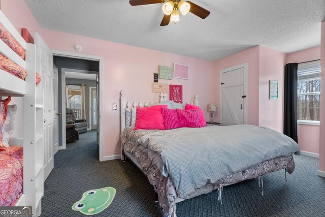 carpeted bedroom with multiple windows, ceiling fan, and a textured ceiling