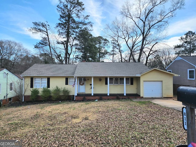 single story home with a garage, a front yard, covered porch, and concrete driveway