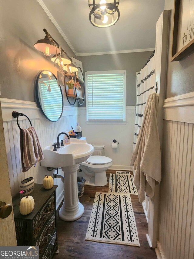 bathroom featuring hardwood / wood-style floors, toilet, and ornamental molding