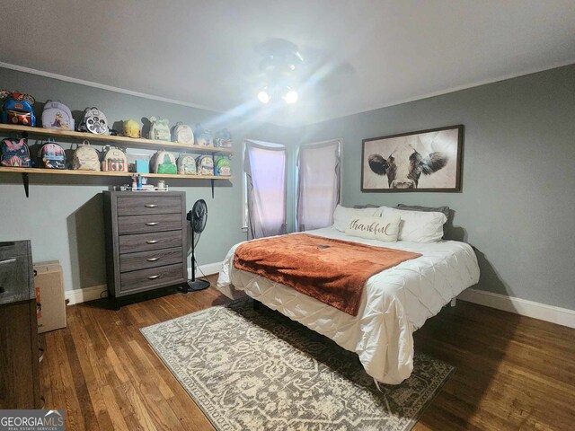 bedroom with dark hardwood / wood-style floors and crown molding