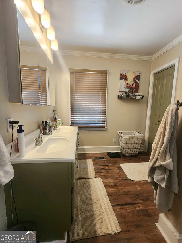 bathroom with wood-type flooring, vanity, and crown molding