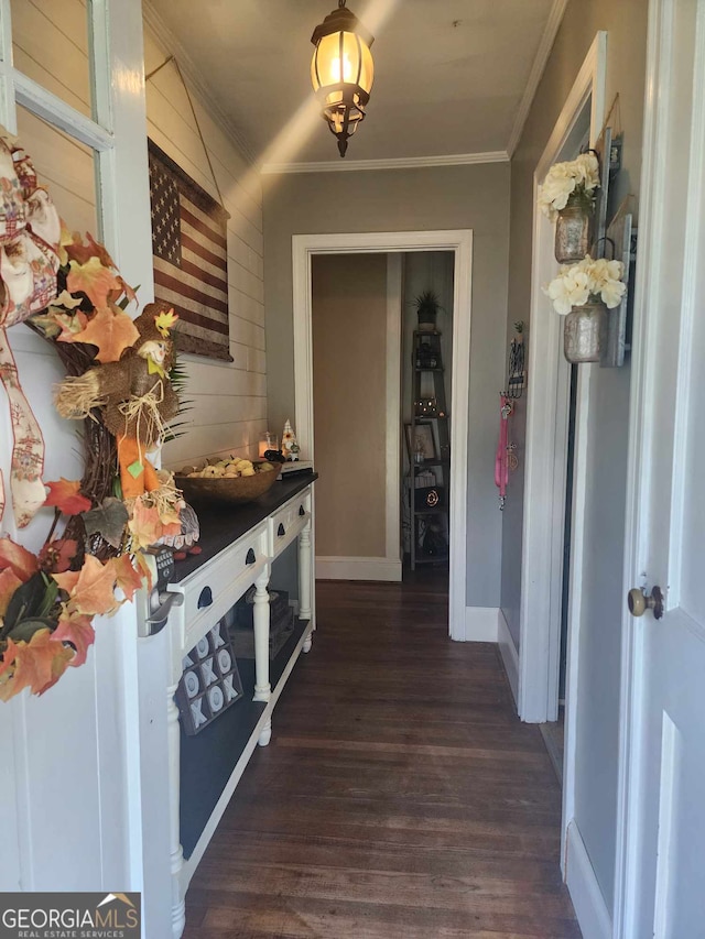 interior space with baseboards, ornamental molding, and dark wood-type flooring