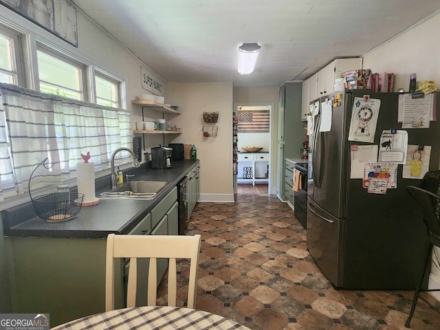 kitchen featuring white cabinetry, sink, stainless steel refrigerator, and black / electric stove