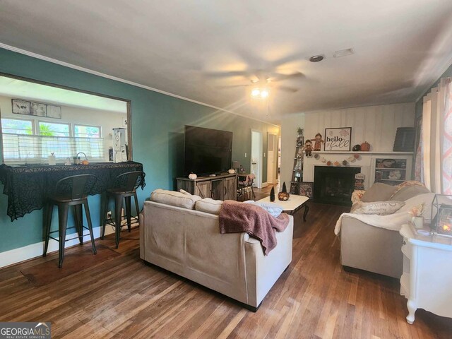 living room with ceiling fan, crown molding, and wood-type flooring