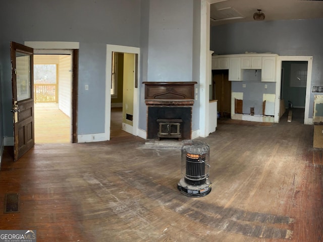 unfurnished living room with a high ceiling and dark wood-type flooring