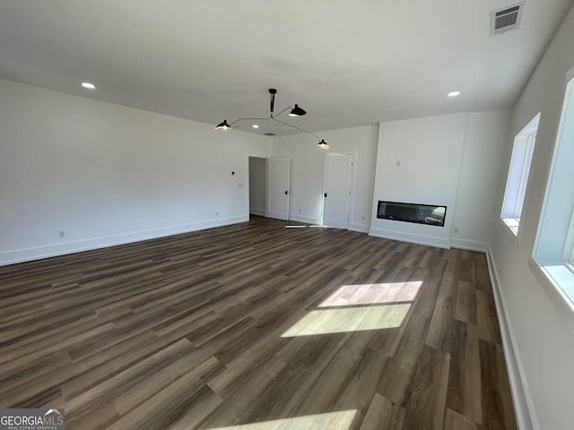 unfurnished living room with dark wood-type flooring