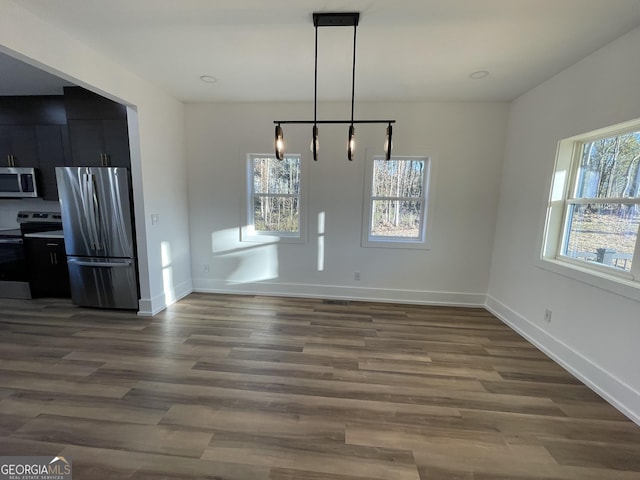 unfurnished dining area with a wealth of natural light and dark wood-type flooring