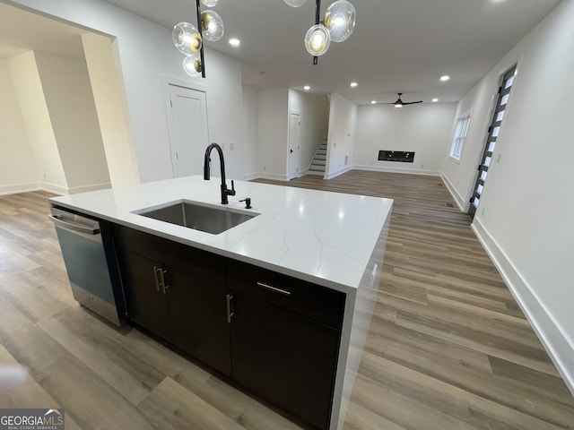 kitchen featuring dishwasher, an island with sink, sink, hanging light fixtures, and ceiling fan