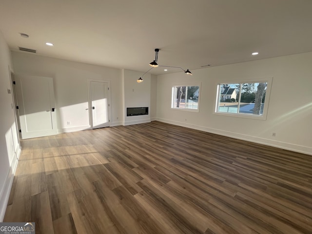 unfurnished living room with dark wood-type flooring