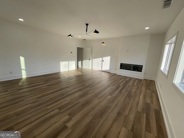 unfurnished living room with dark wood-type flooring