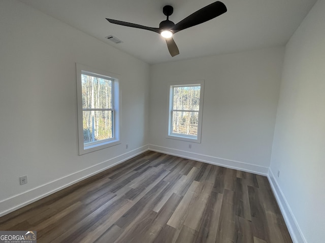 empty room with dark wood-type flooring and ceiling fan