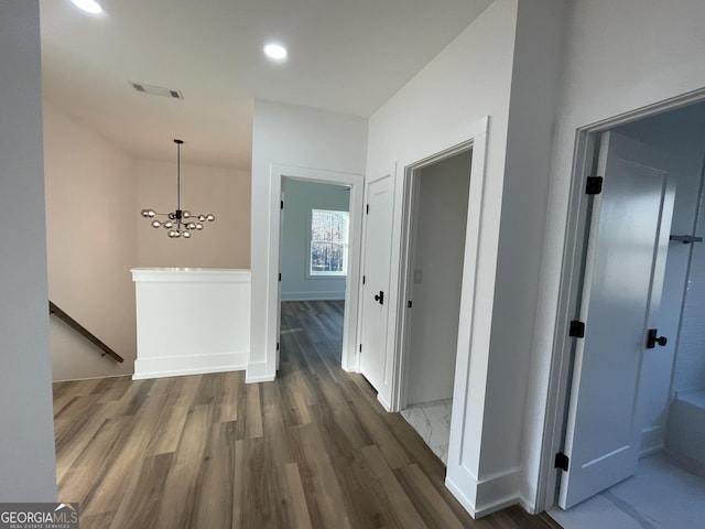 hall featuring dark hardwood / wood-style flooring and a chandelier