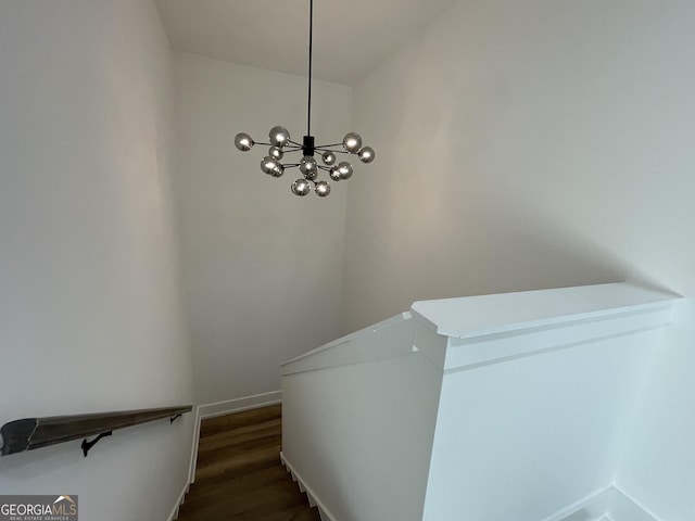 stairway featuring wood-type flooring and a chandelier