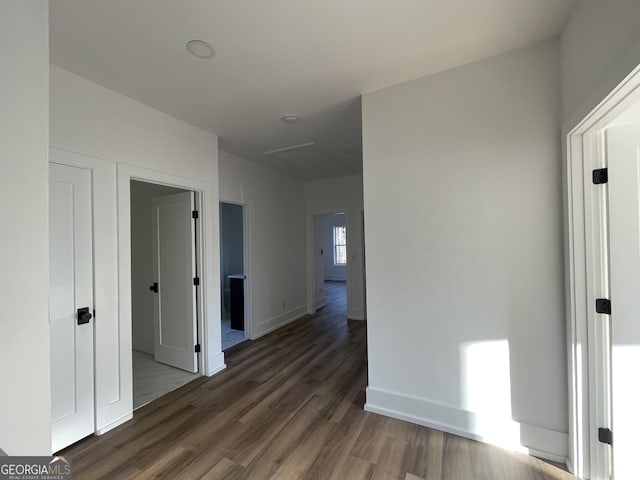 corridor with dark hardwood / wood-style flooring