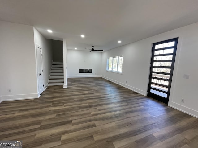 unfurnished living room with ceiling fan and dark hardwood / wood-style flooring