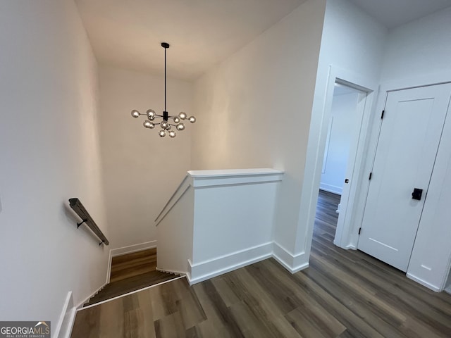 staircase featuring wood-type flooring and a chandelier