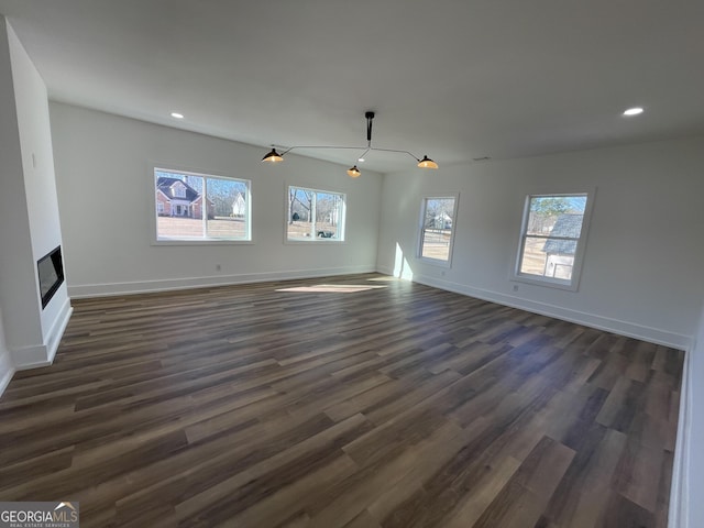 unfurnished living room with dark wood-type flooring