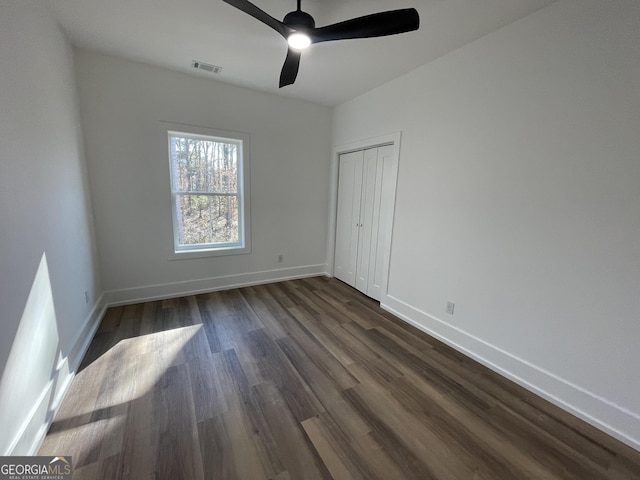 spare room with dark hardwood / wood-style floors and ceiling fan