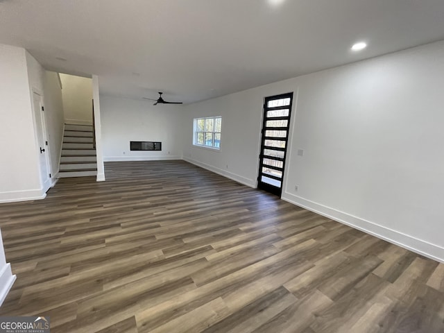 unfurnished living room featuring dark hardwood / wood-style floors and ceiling fan