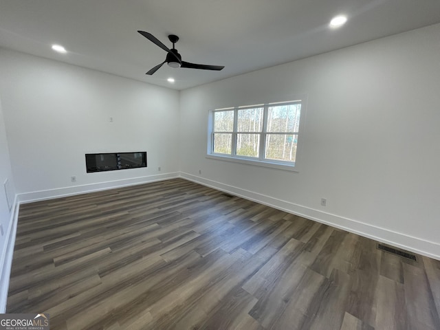 unfurnished living room with dark hardwood / wood-style floors and ceiling fan