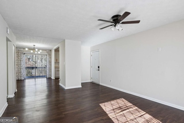 empty room featuring a textured ceiling, ceiling fan with notable chandelier, and dark wood-type flooring