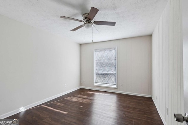 empty room featuring dark hardwood / wood-style floors, ceiling fan, a textured ceiling, and wooden walls