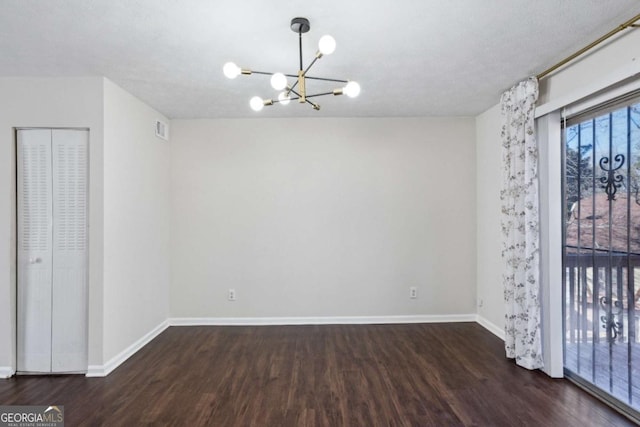 interior space with dark hardwood / wood-style floors, a textured ceiling, and a chandelier