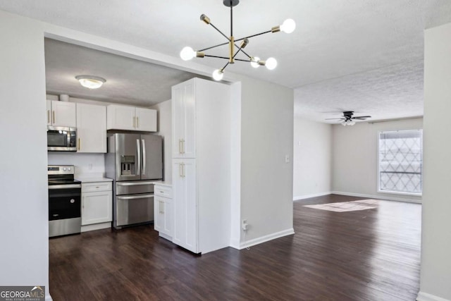 kitchen featuring white cabinetry, stainless steel appliances, dark hardwood / wood-style flooring, pendant lighting, and ceiling fan with notable chandelier